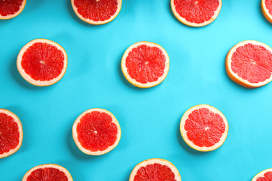 Photo of Tasty ripe grapefruit slices on blue background, flat lay