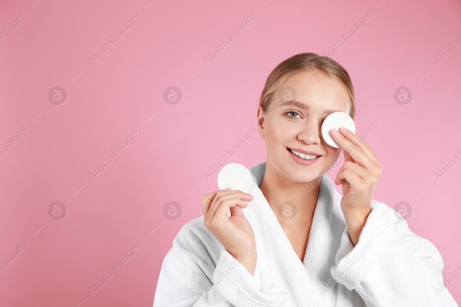 Photo of Beautiful young woman with cotton pads on pink background. Space for text