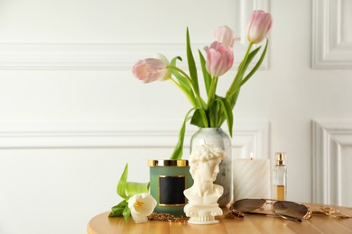 David bust candle and tulips on wooden table, space for text. Stylish decor