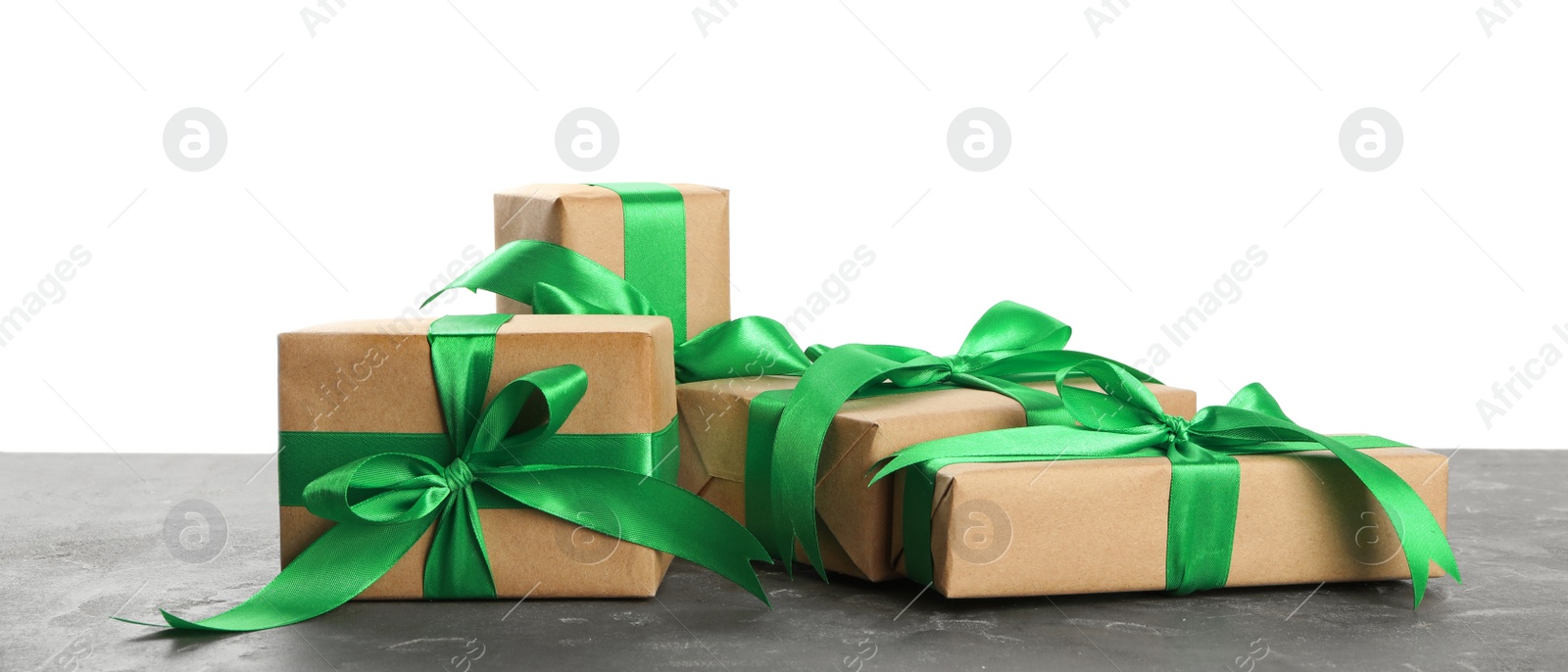 Photo of Many Christmas gifts on grey table against white background