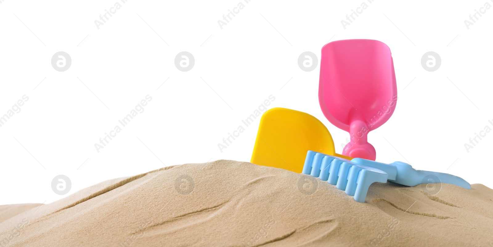 Photo of Plastic toy set with shovel on pile of sand