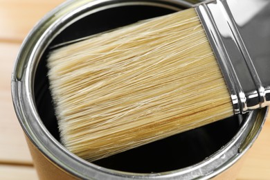 Photo of Can with varnish and brush, closeup view