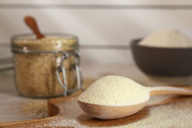 Photo of Wooden spoon with quinoa flour on table, closeup