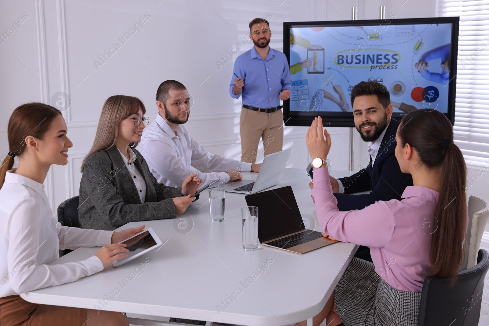 Photo of Business trainer near interactive board in meeting room during presentation