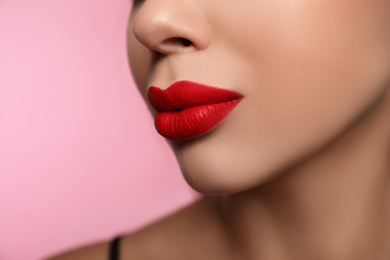 Photo of Woman with red lipstick on pink background, closeup