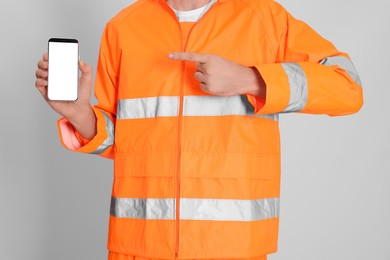 Man in reflective uniform with phone on white background, closeup