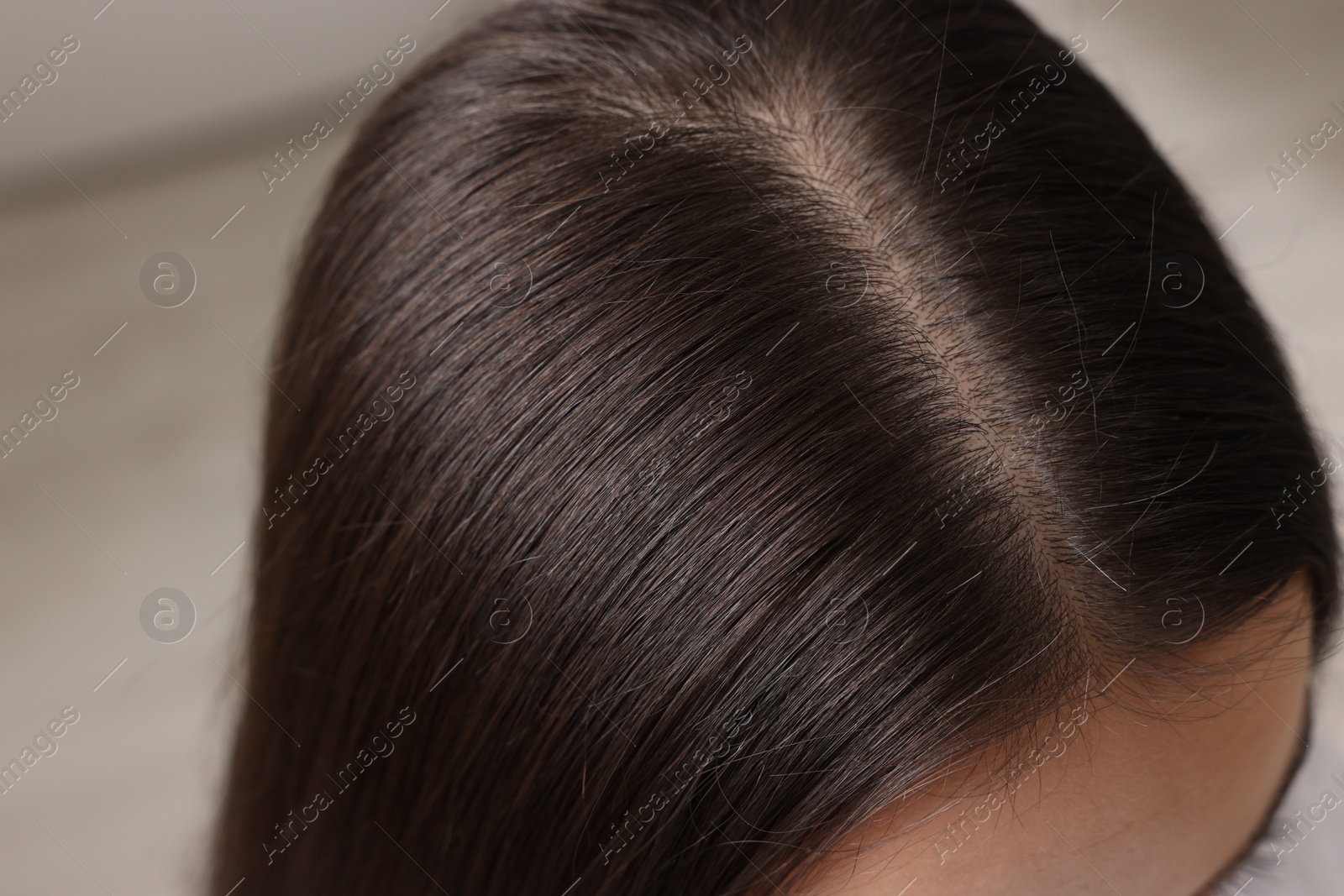 Photo of Woman with healthy hair on blurred background, closeup view