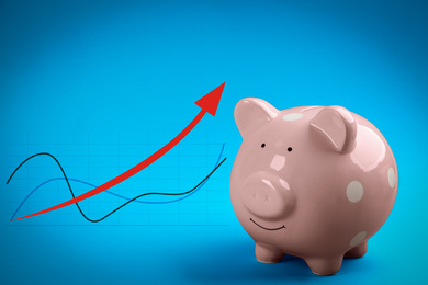 Pink piggy bank and graph on blue background