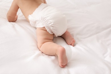 Photo of Little baby in diaper on bed, closeup