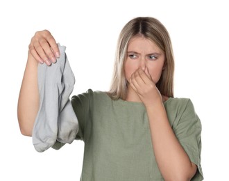 Young woman feeling bad smell from dirty socks isolated on white