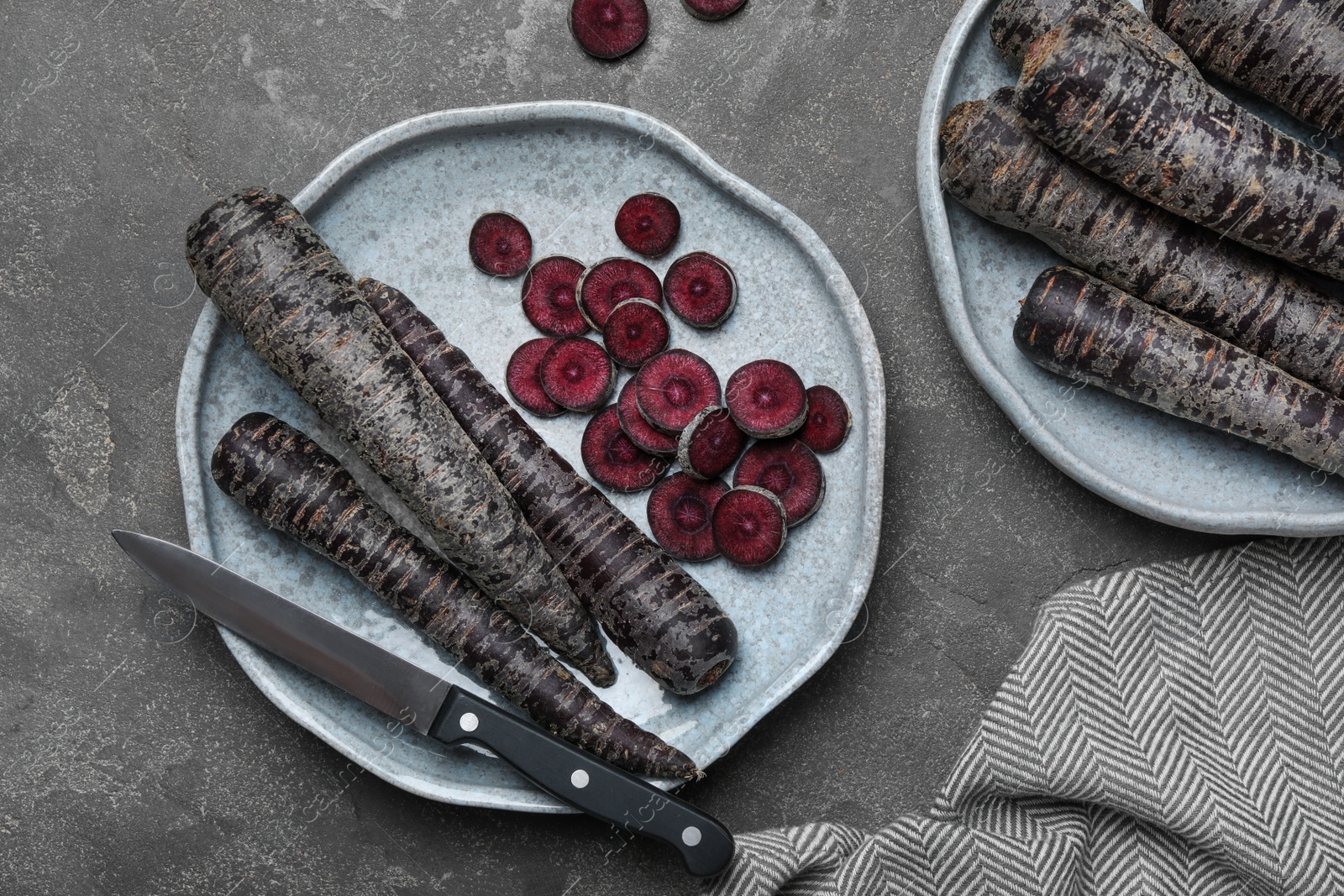 Photo of Flat lay composition with raw black carrots on grey table