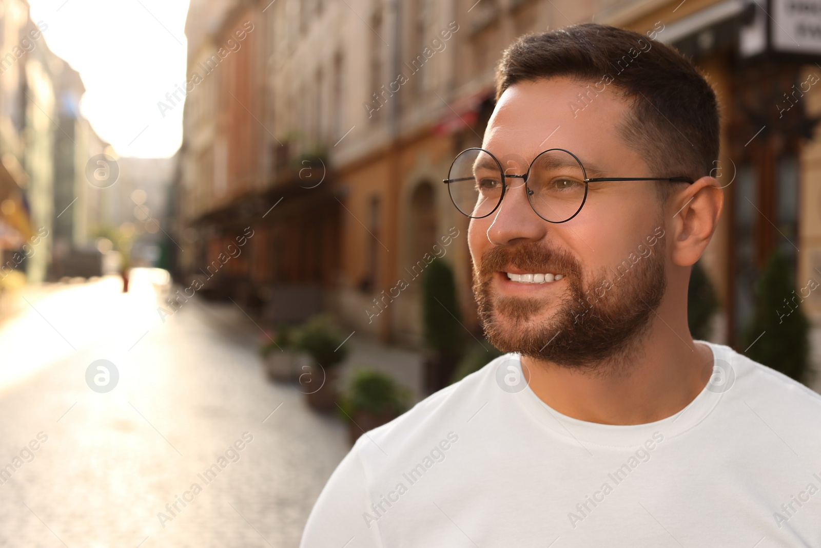 Photo of Portrait of handsome bearded man in glasses outdoors, space for text