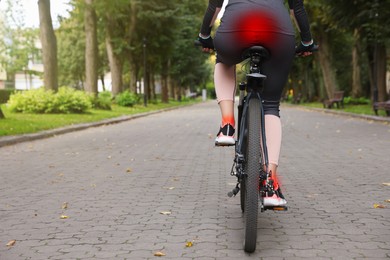 Image of Problem of injured coccyx. Woman riding bicycle on road