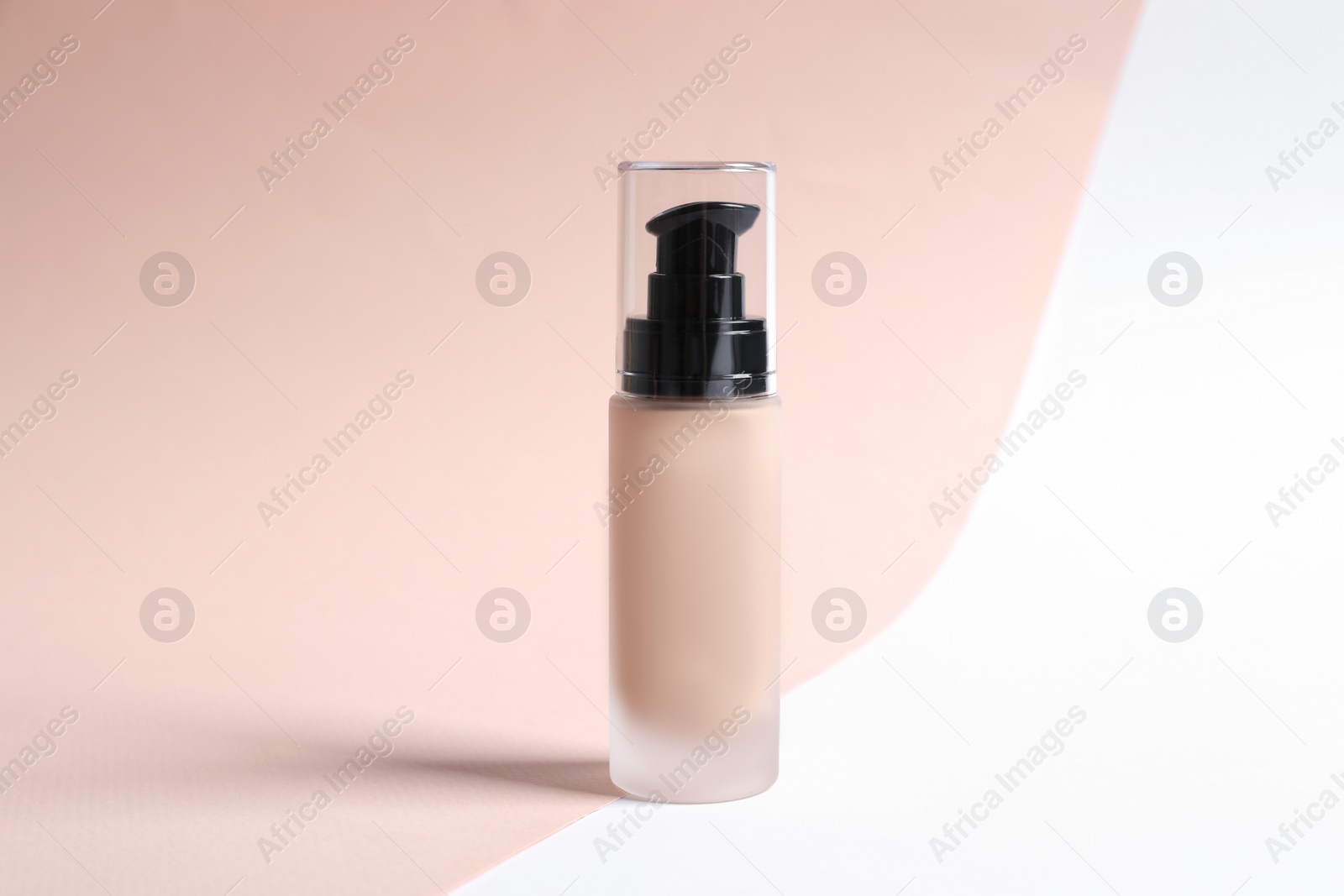 Photo of Bottle of skin foundation on color background. Makeup product