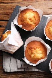 Photo of Delicious sweet muffins on wooden table, top view