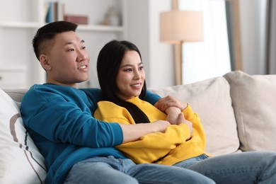 Photo of Happy young couple on sofa at home