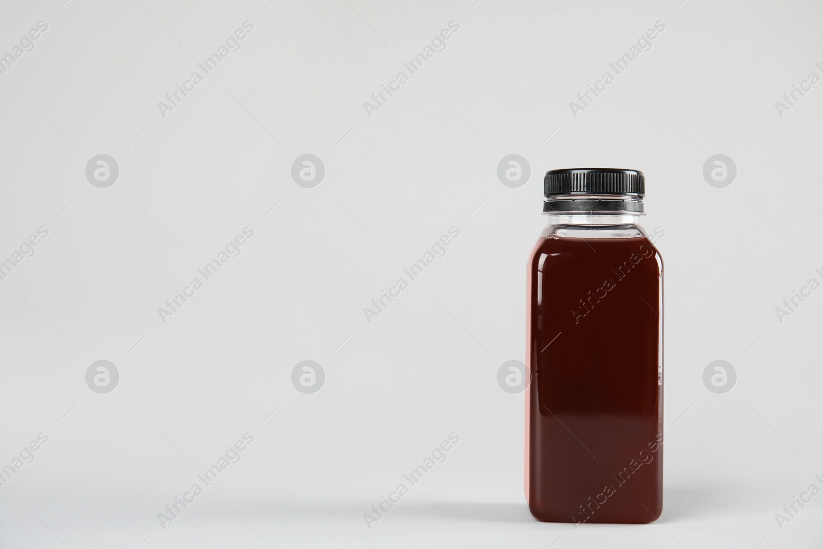 Photo of One bottle with tasty drink on color background. Space for text