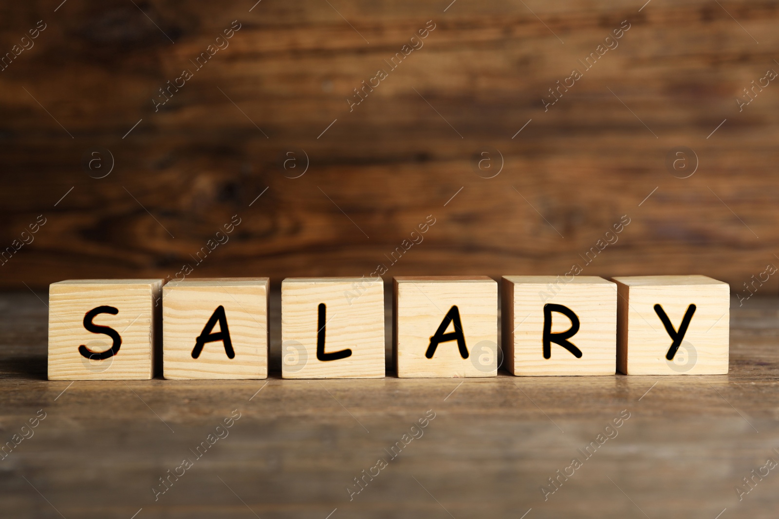 Image of Word Salary made with cubes on wooden table