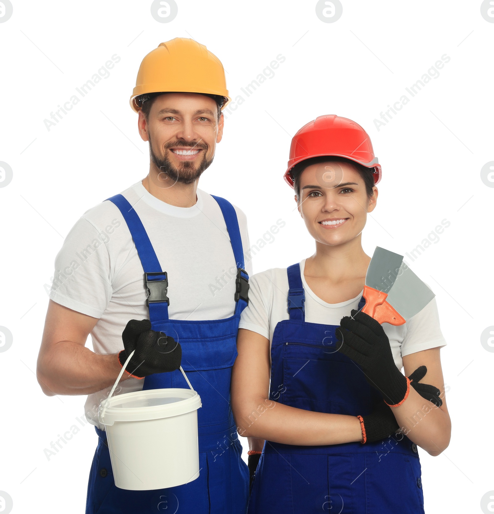 Photo of Professional workers with putty knives and plaster in hard hats on white background