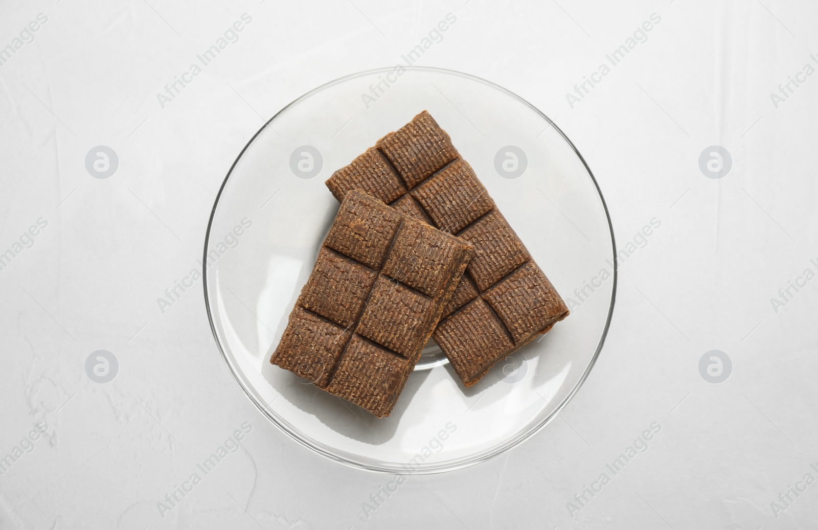 Photo of Glass plate with delicious and healthy hematogen on white table, top view