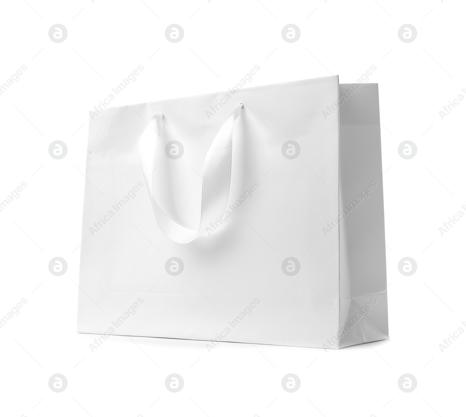 Photo of Paper shopping bag with ribbon handles on white background. Mockup for design