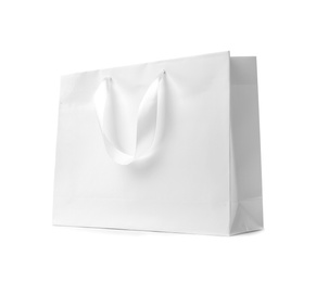 Photo of Paper shopping bag with ribbon handles on white background. Mockup for design