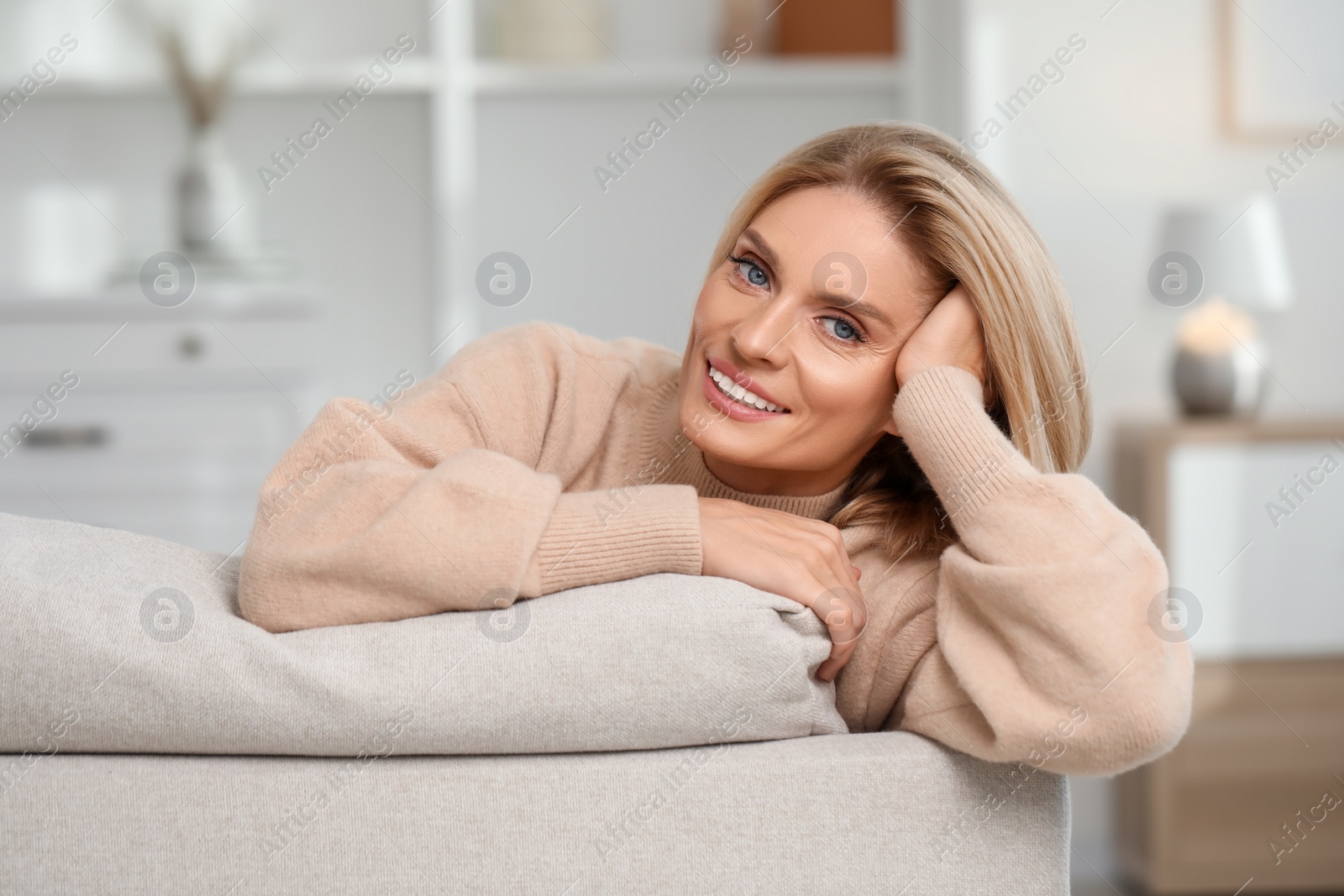 Photo of Portrait of smiling middle aged woman with blonde hair at home