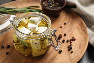 Jar with feta cheese marinated in oil on table. Pickled food