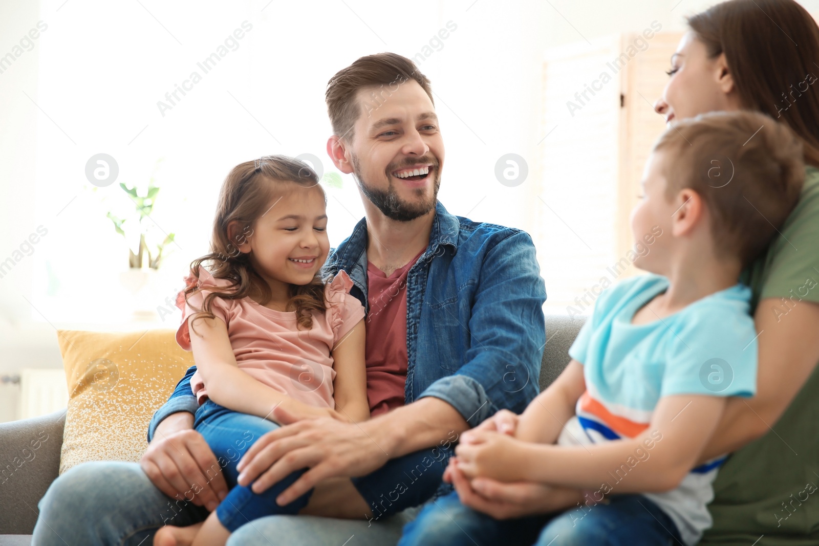 Photo of Young happy family with children at home