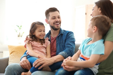 Photo of Young happy family with children at home