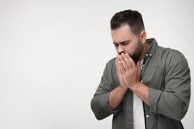 Photo of Sick man coughing on white background, space for text