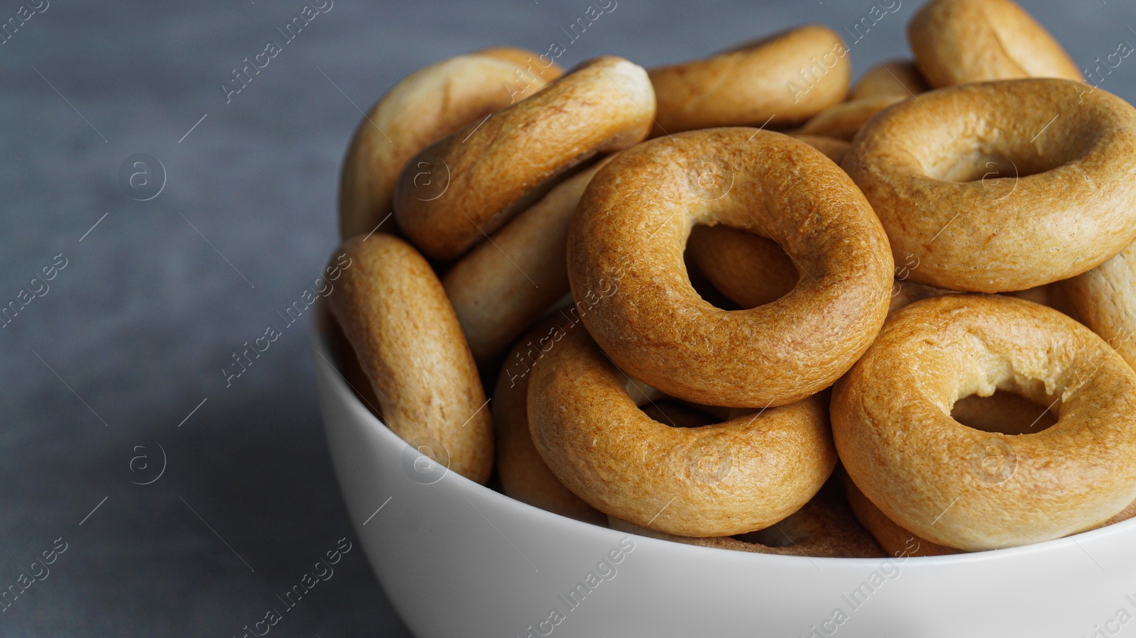 Photo of Tasty dry bagels (sushki) in bowl, closeup