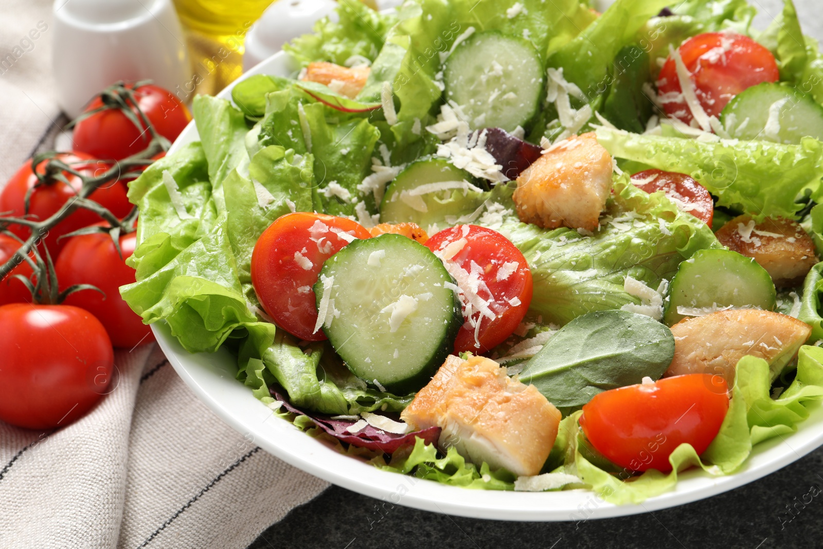 Photo of Delicious salad with chicken, cheese and vegetables on table, closeup