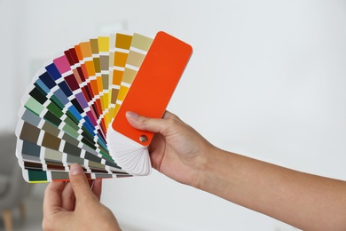 Photo of Female interior designer with color palette samples indoors, closeup