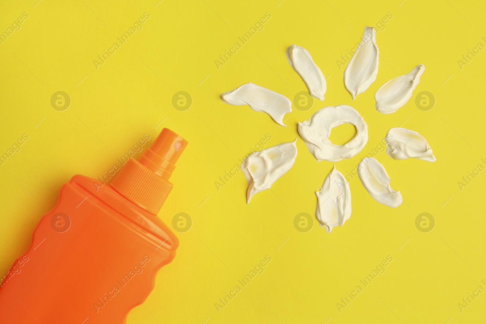 Photo of Drawing of sun and bottle with sunscreen on yellow background, top view. Skin protection