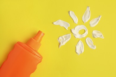 Photo of Drawing of sun and bottle with sunscreen on yellow background, top view. Skin protection