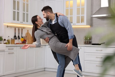 Photo of Happy lovely couple dancing together in kitchen