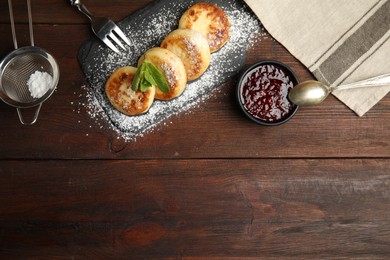 Photo of Delicious cottage cheese pancakes with icing sugar and jam on wooden table, flat lay. Space for text