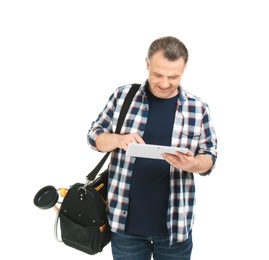 Mature plumber with tablet computer and tool bag on white background