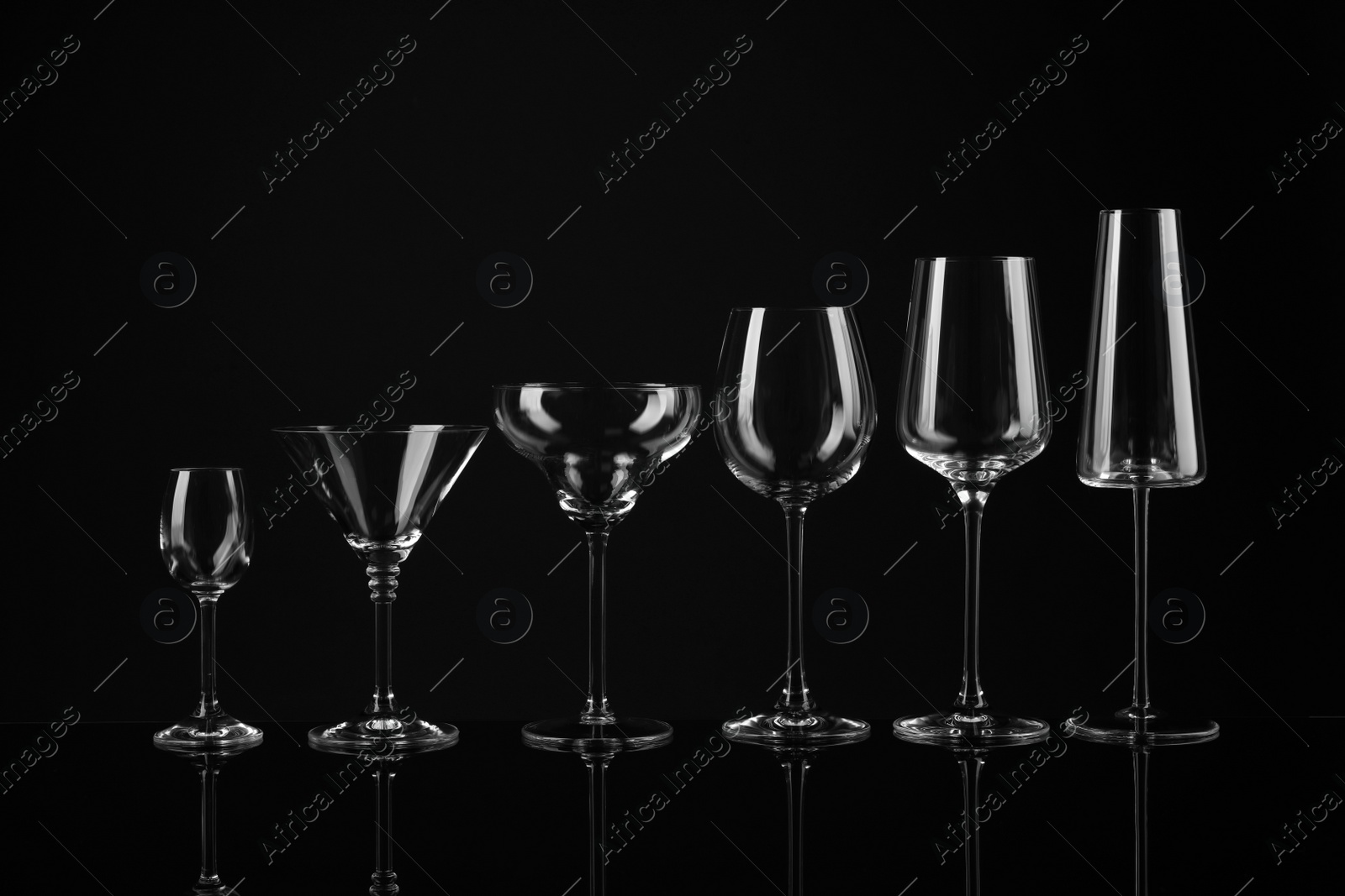 Photo of Set of empty glasses on black background