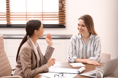 Female insurance agent consulting young woman in office