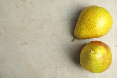 Photo of Ripe juicy pears on grey stone table, top view. Space for text