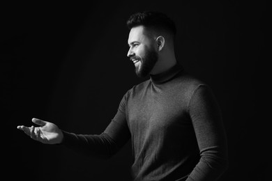 Portrait of handsome bearded man on dark background. Black and white effect