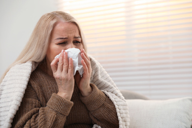 Mature woman suffering from cold at home. Dangerous virus