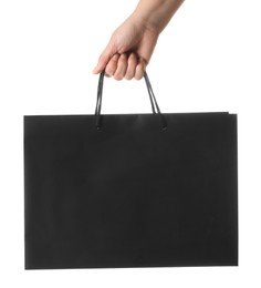 Photo of Woman holding black paper bag on white background, closeup