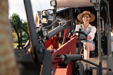 Photo of Smiling farmer driving loader outdoors. Agriculture equipment