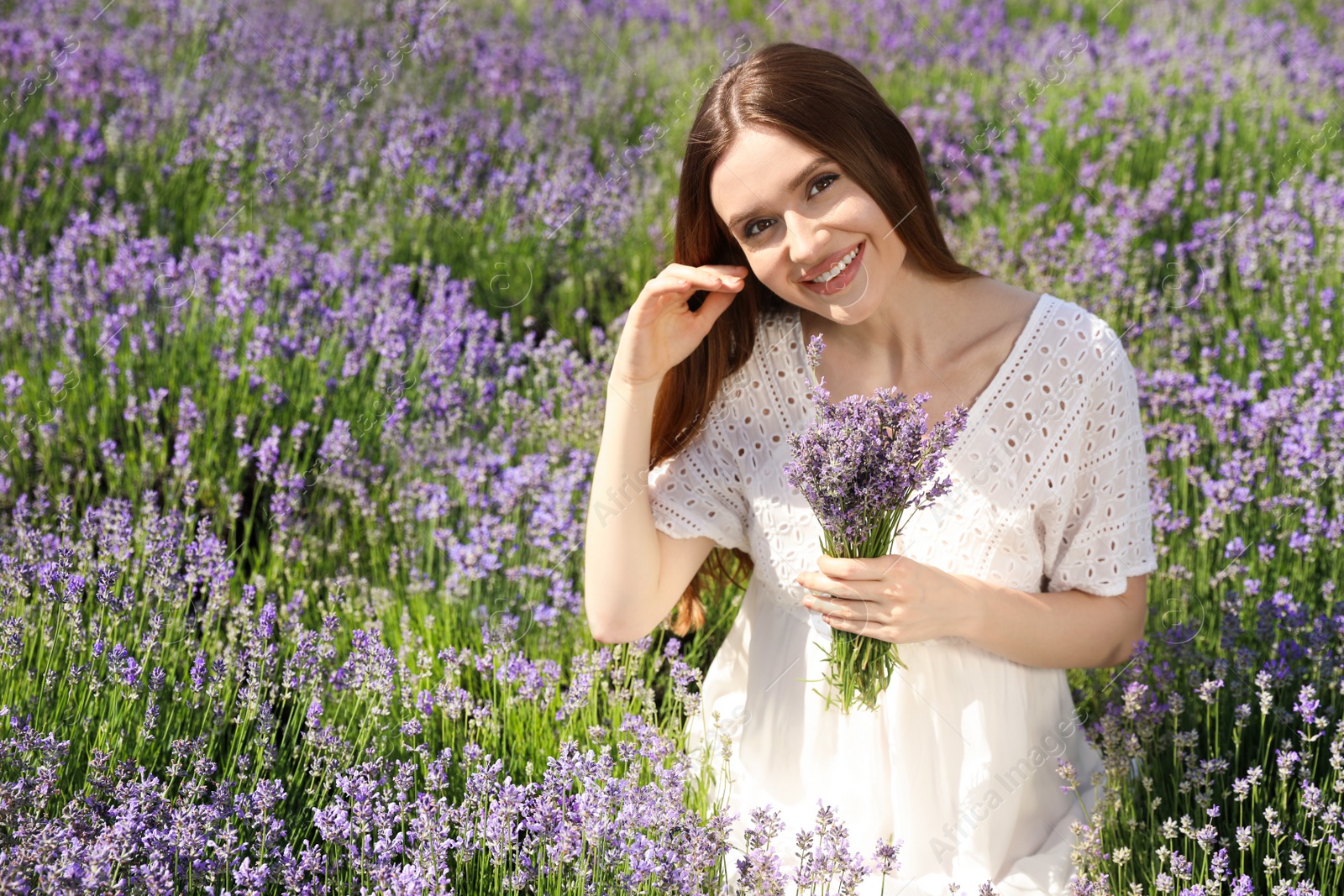 Photo of Young woman with lavender bouquet in field on summer day