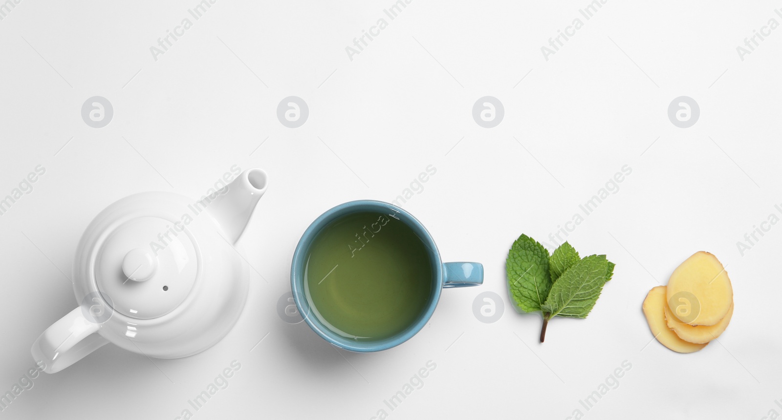 Photo of Cup with hot tea, ginger and teapot on white background, top view. Space for text