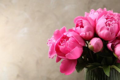 Photo of Beautiful peony bouquet in vase on grey background. Space for text