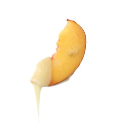 Photo of Fondue fork with slice of peach dipped into chocolate on white background